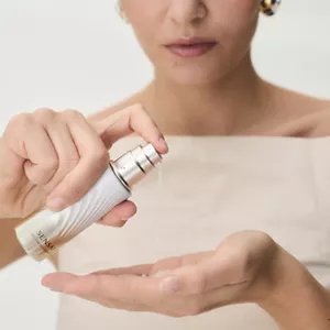 Close up of person holding and dispensing Lift Focus Essence on their hand before application